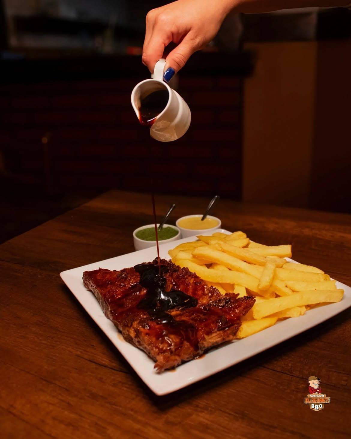 Costilla BBQ con la salsa cayendo desde una jarrita