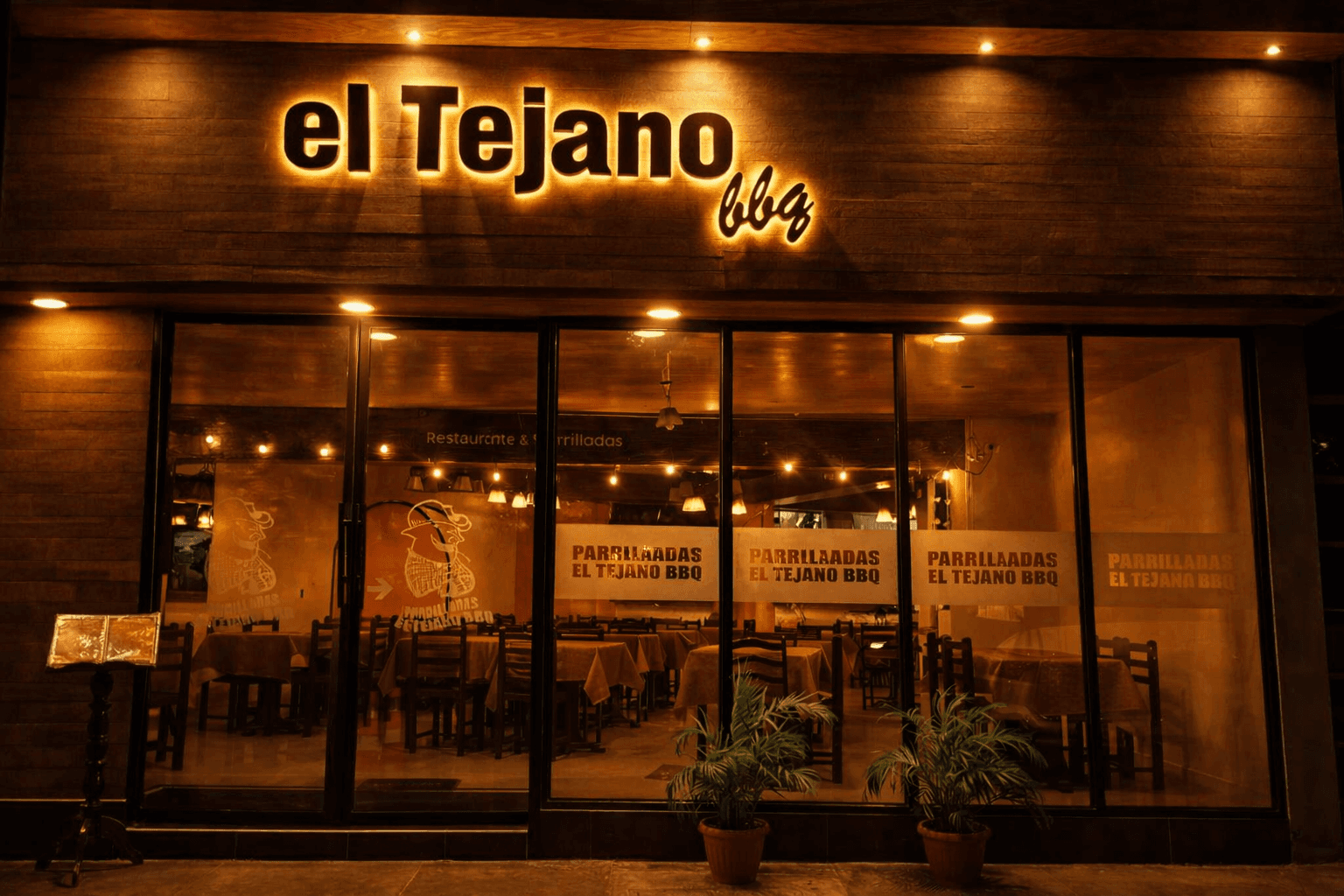 Fachada exterior de El Tejano BBQ de noche